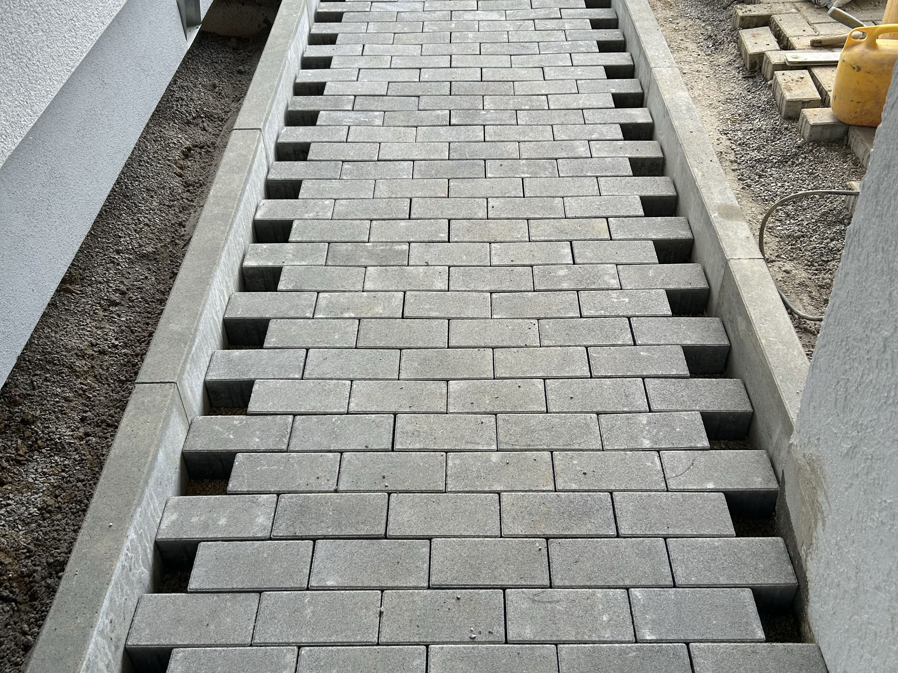 Pflasterarbeiten entlang einer Hauswand