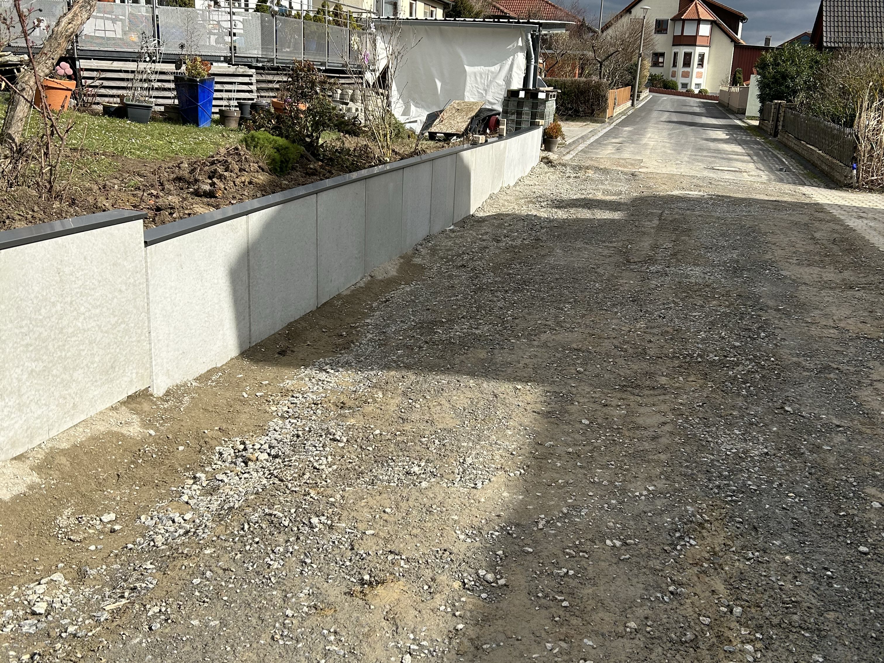 Stützmauer aus L-Steinen an einer Hofeinfahrt