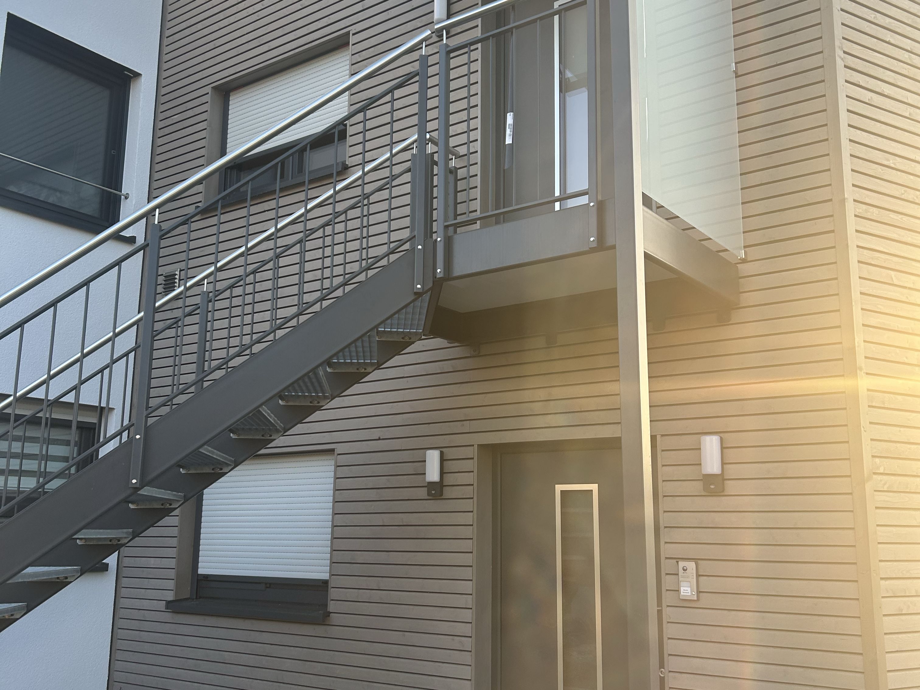 Außentreppe aus Metall mit Geländer an modernem Wohnhaus