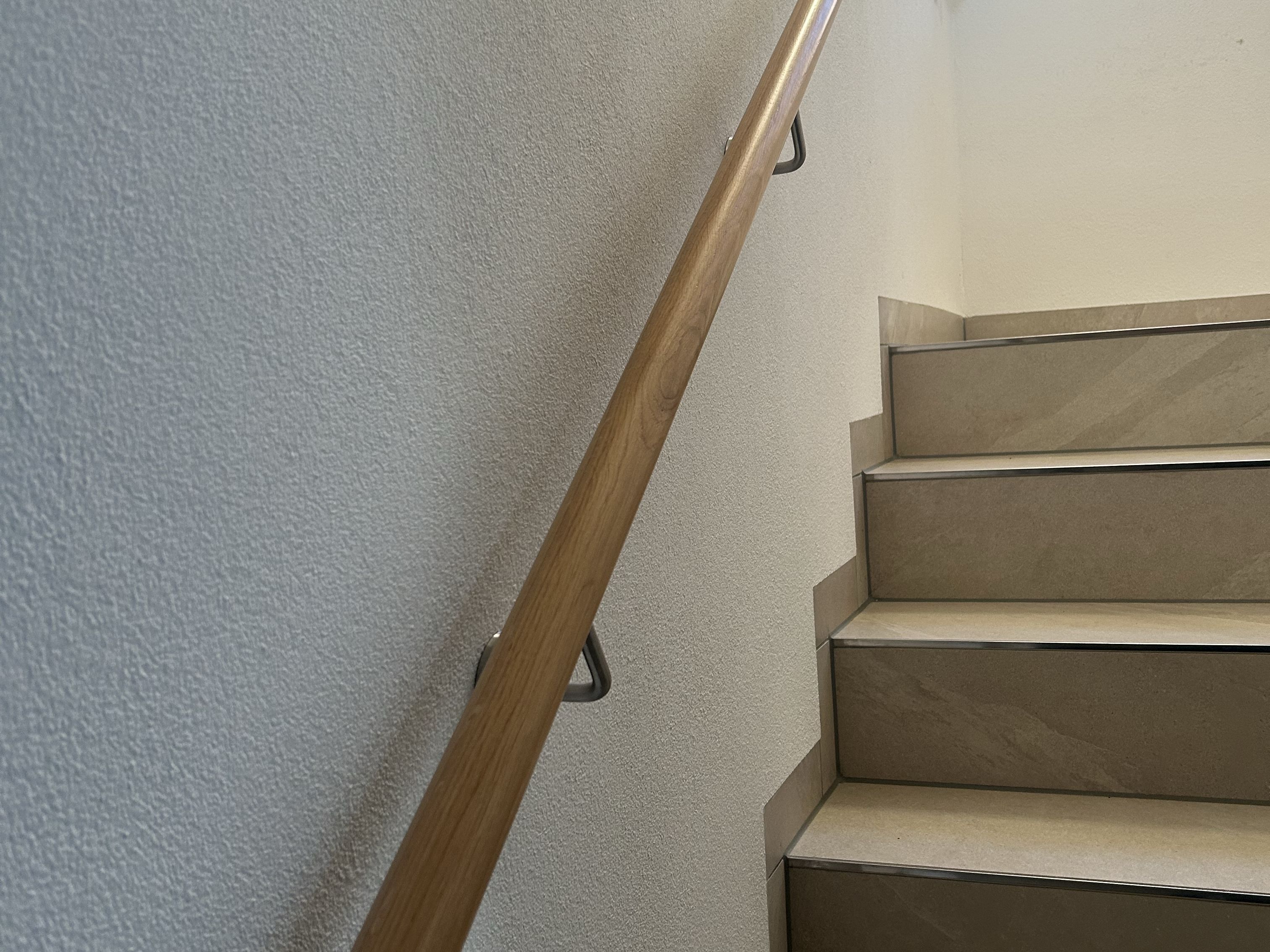 Wandbefestigtes Treppengeländer aus Edelstahl mit Holzhandlauf