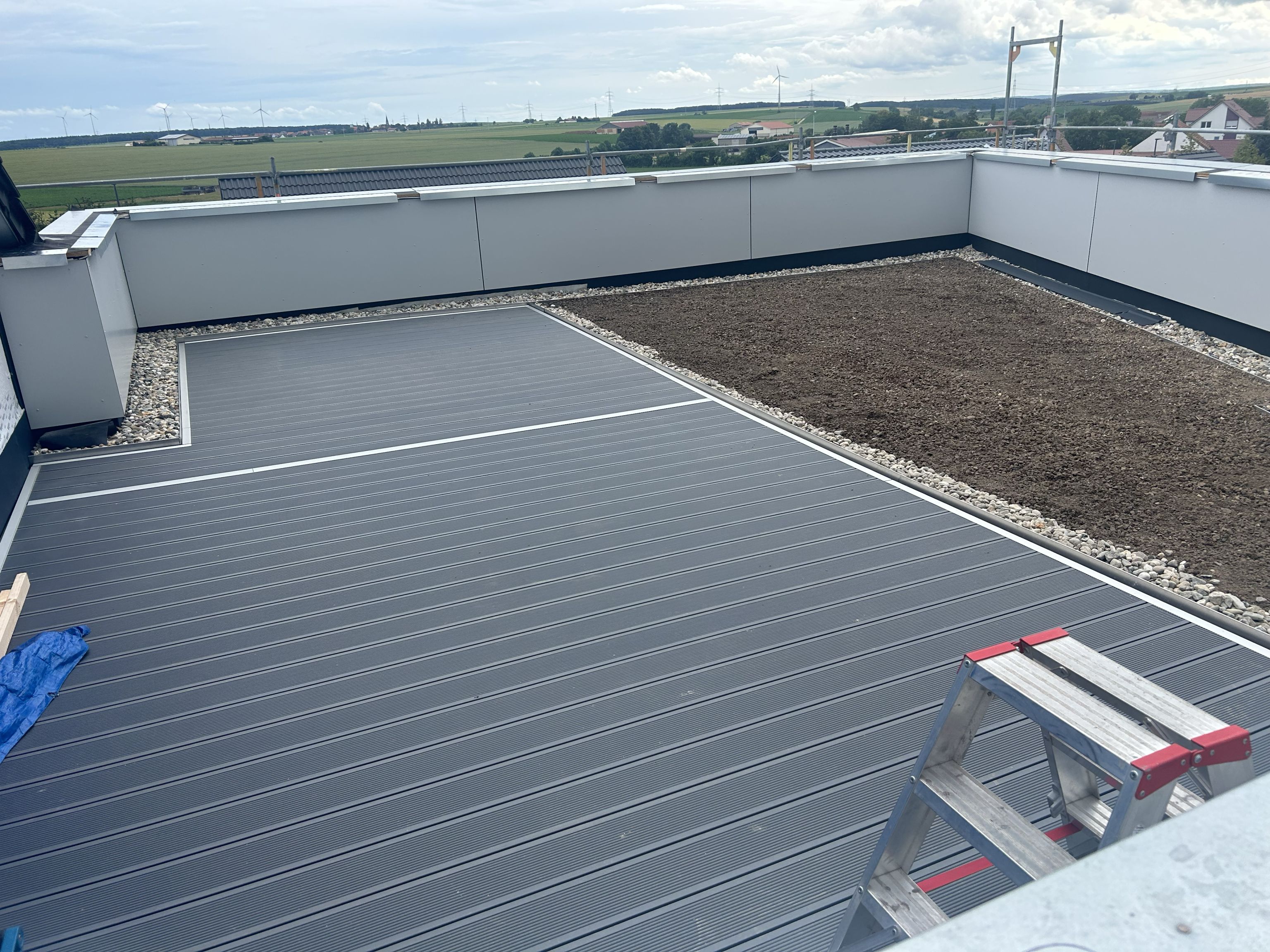 Dachterrasse mit anthrazitfarbenen WPC-Dielen und Sichtschutz