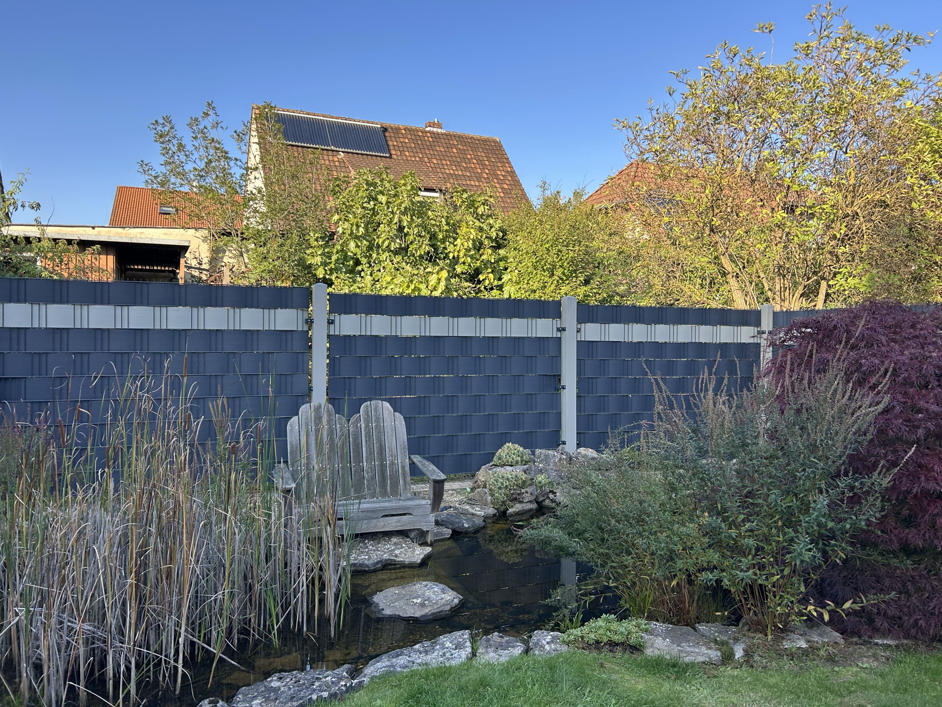 Zaunanlage mit Sichtschutzstreifen in einem gepflegten Garten