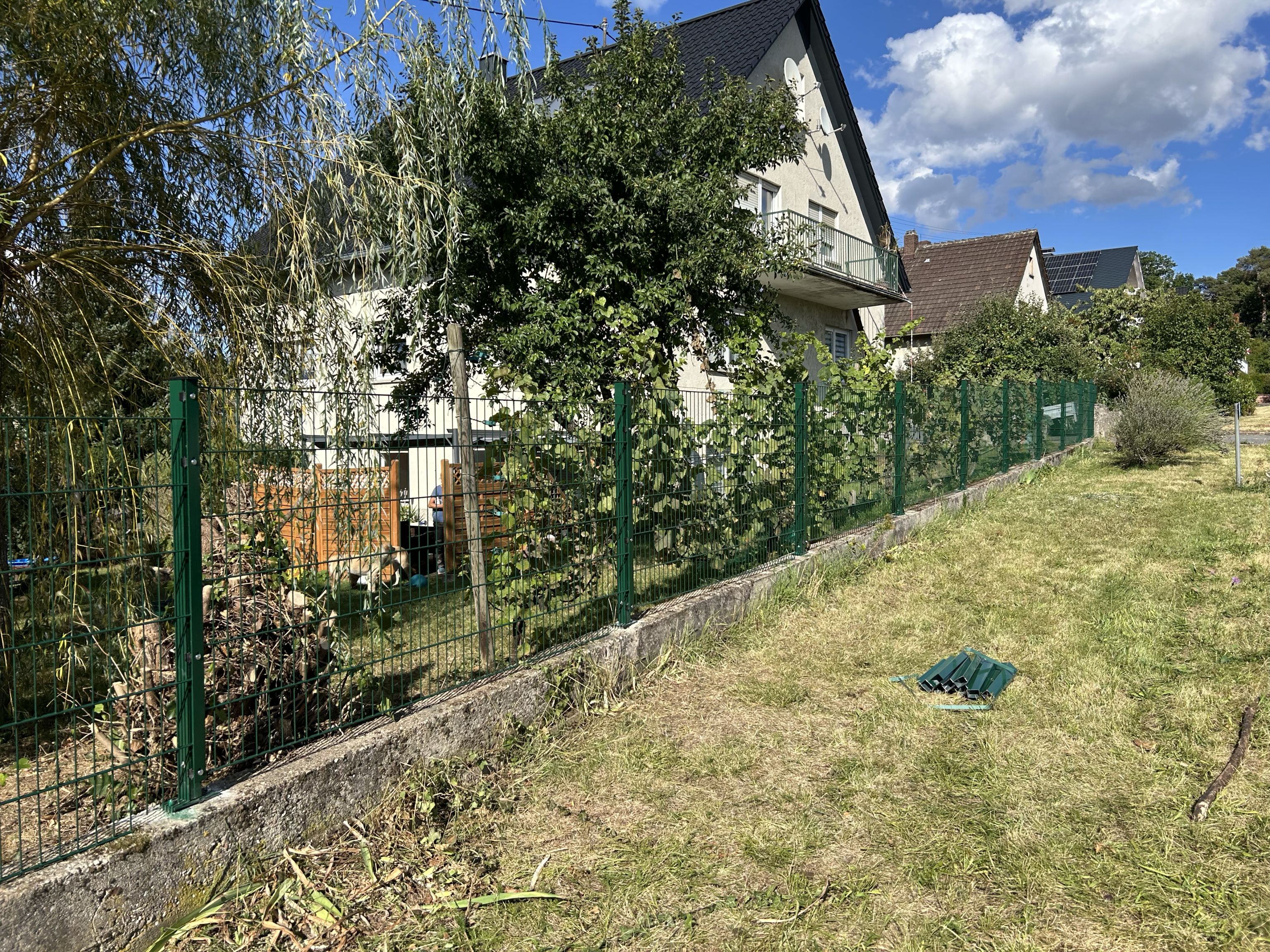 Grüner Stabmattenzaun auf bestehendem Mauersockel